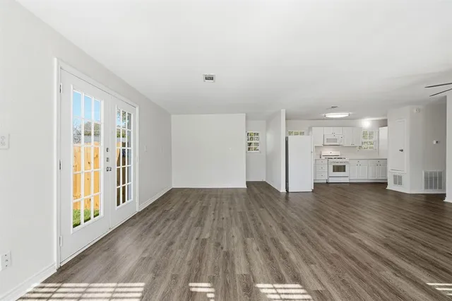 a view of a kitchen with wooden floor and a window