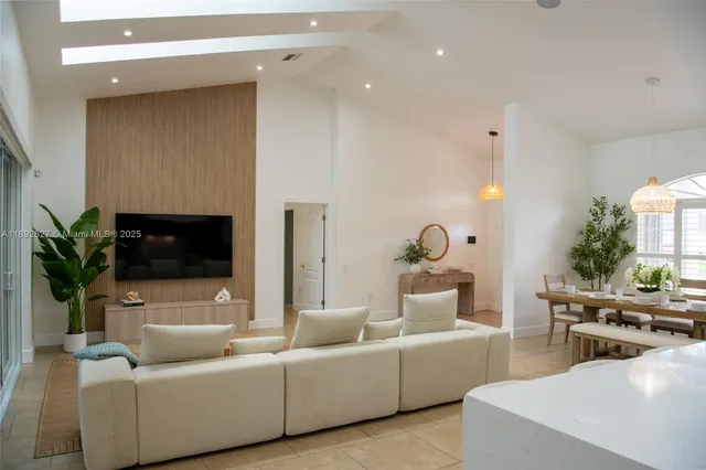 a dining room with furniture and a large window