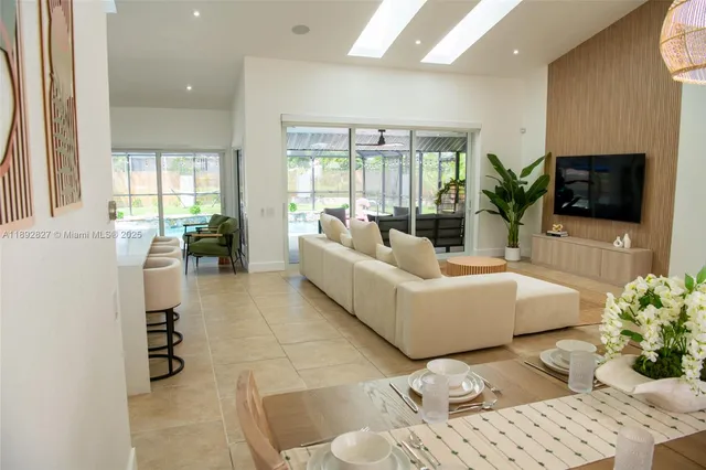 a view of a swimming pool with a yard chairs and floor to ceiling window