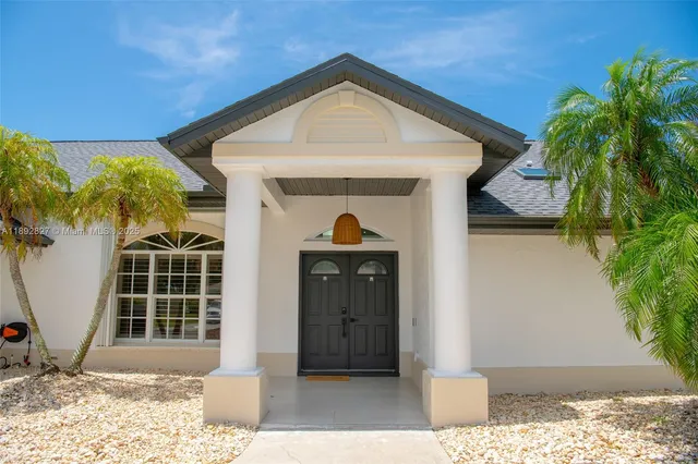 a large white bed sitting in a bedroom next to a window