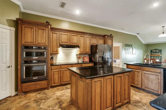 a kitchen with stainless steel appliances granite countertop a sink stove and refrigerator