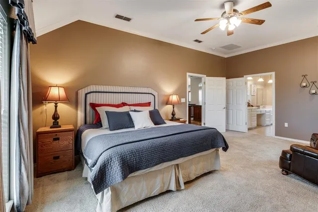 a spacious bedroom with a bed and a chandelier
