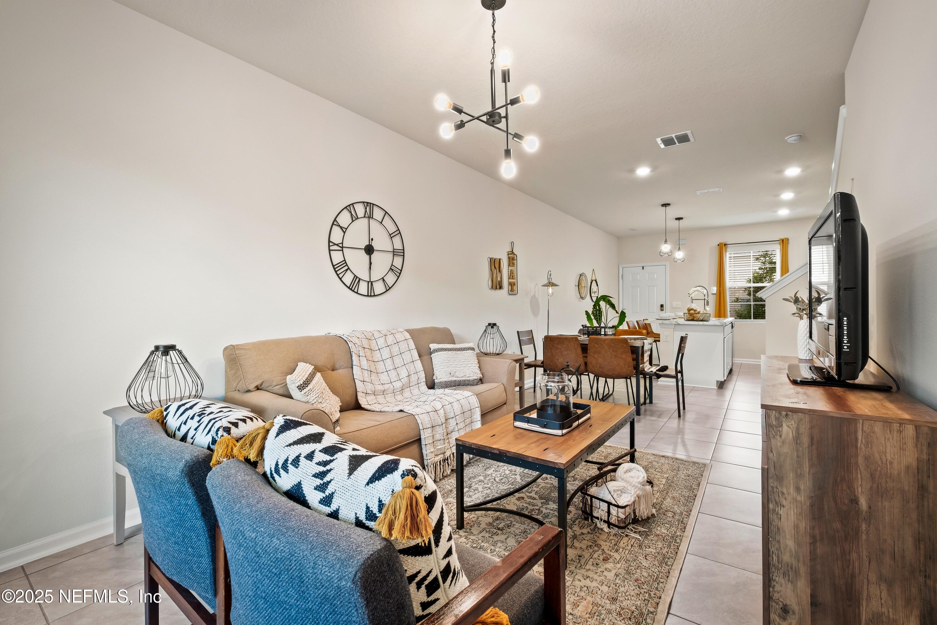 4920 Earthshine Road Jacksonville, FL 32256 - Photo 6 of 16 a living room with furniture a clock and a flat screen tv