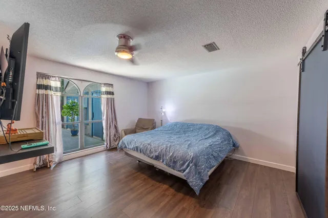a living room with stainless steel appliances kitchen island granite countertop a refrigerator and a sink