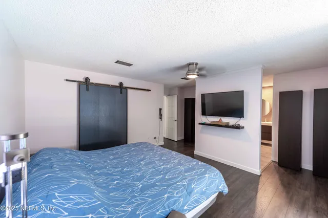 a view of a hallway with wooden floor and a bathroom