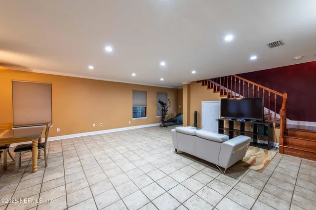 a living room with furniture pool table flat screen tv and outdoor view