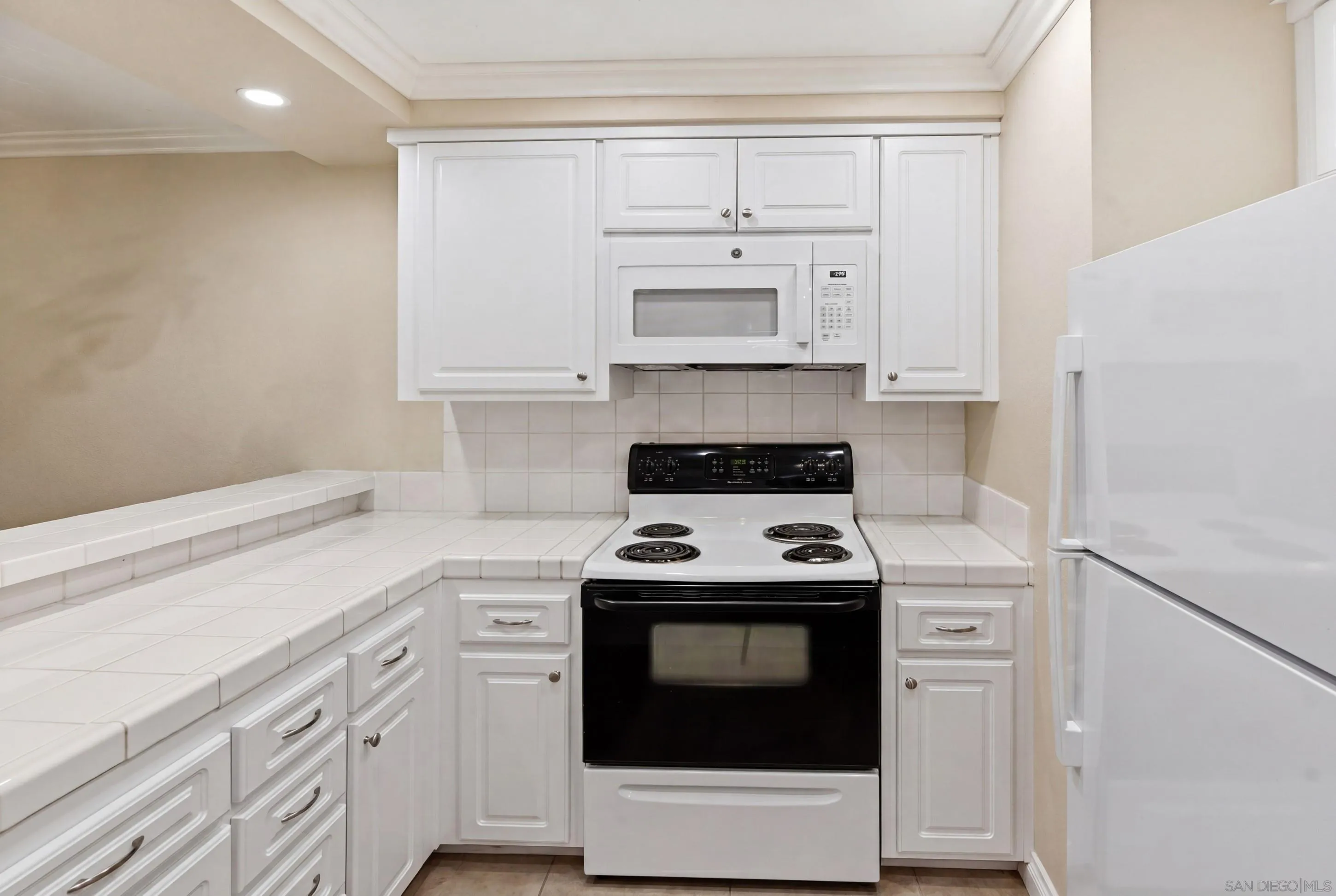 17443 Ashburton Road San Diego, CA 92128 - Photo 10 of 36 a kitchen with white cabinets and white appliances