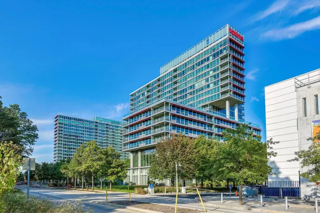 a view of an empty room with a large window and wooden floor