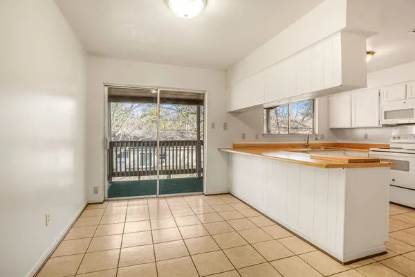 a large white kitchen with a sink and cabinets