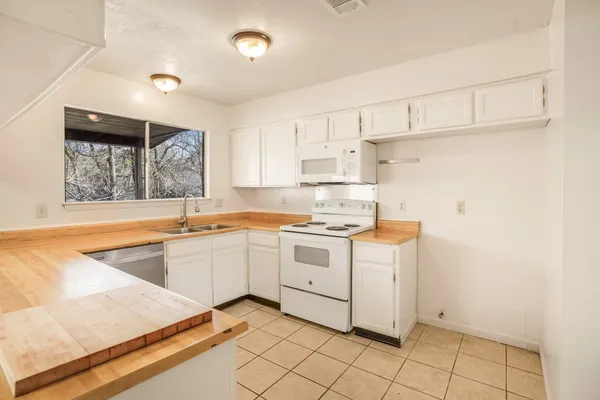 a kitchen with a stove window and white cabinets