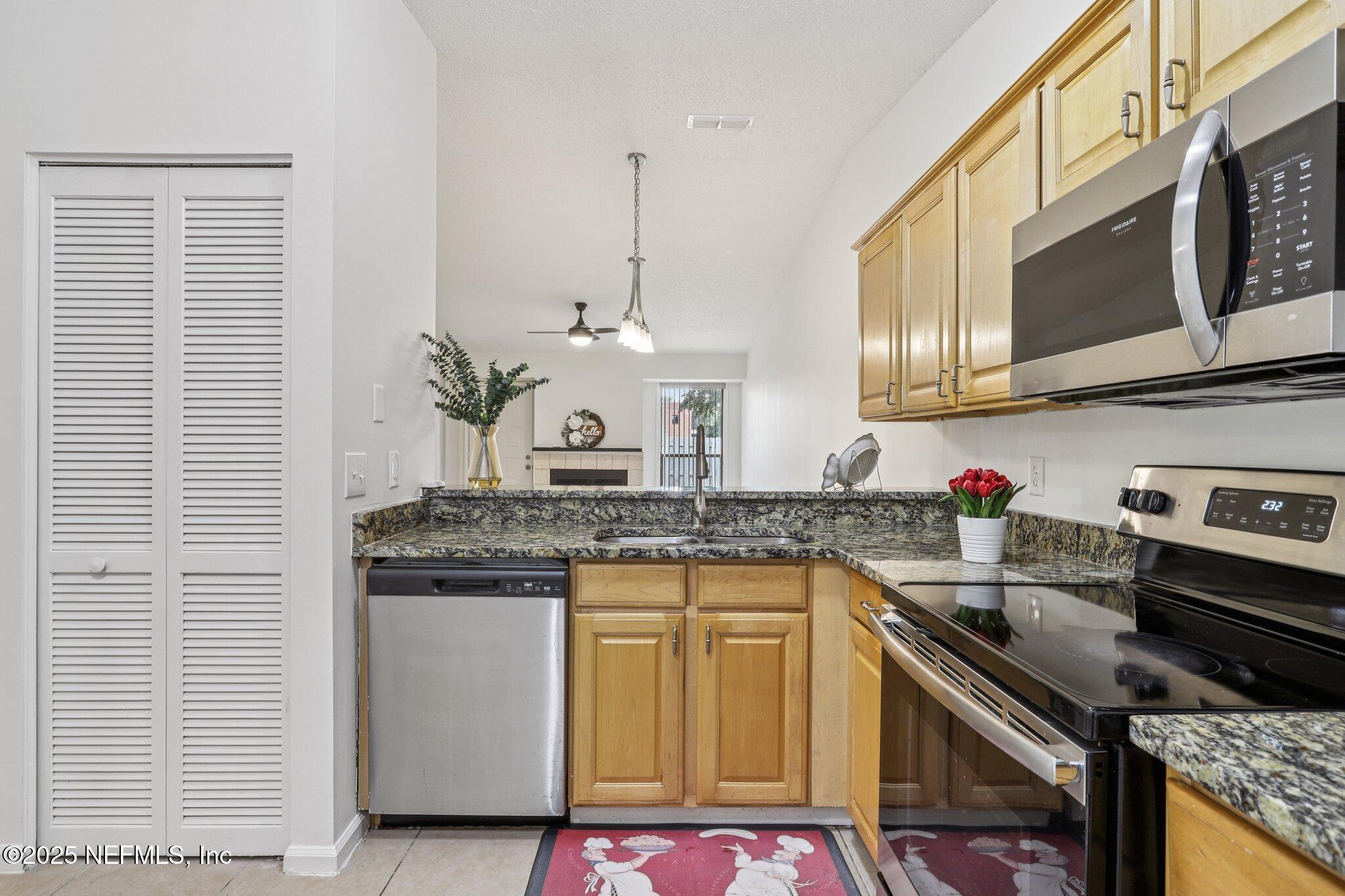 3801 Crown Point Road, Unit 2024 Jacksonville, FL 32257 - Photo 1 of 36 a kitchen with stainless steel appliances granite countertop a stove a sink and a microwave