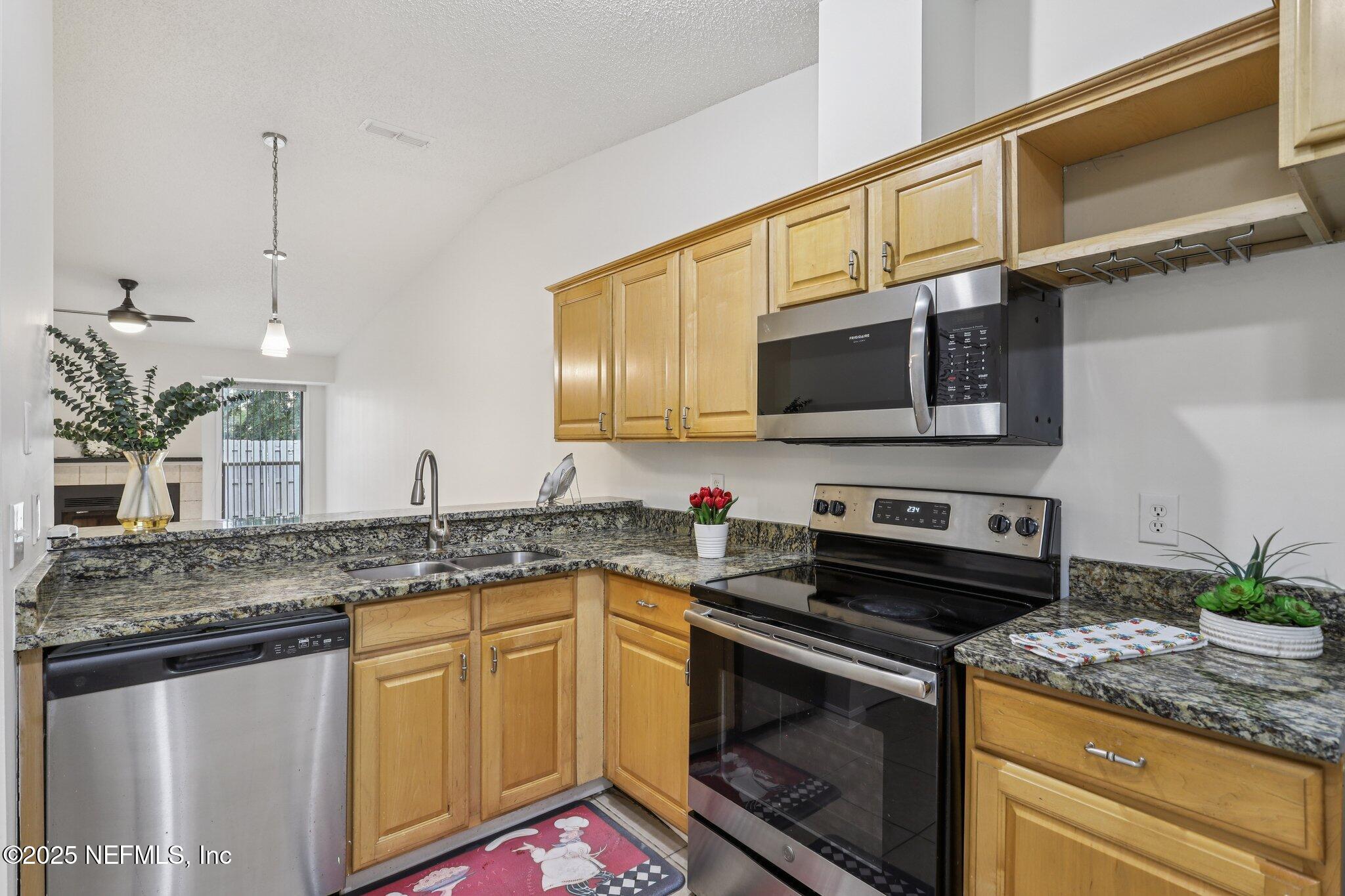 3801 Crown Point Road, Unit 2024 Jacksonville, FL 32257 - Photo 11 of 36 a kitchen with stainless steel appliances granite countertop a sink stove and microwave