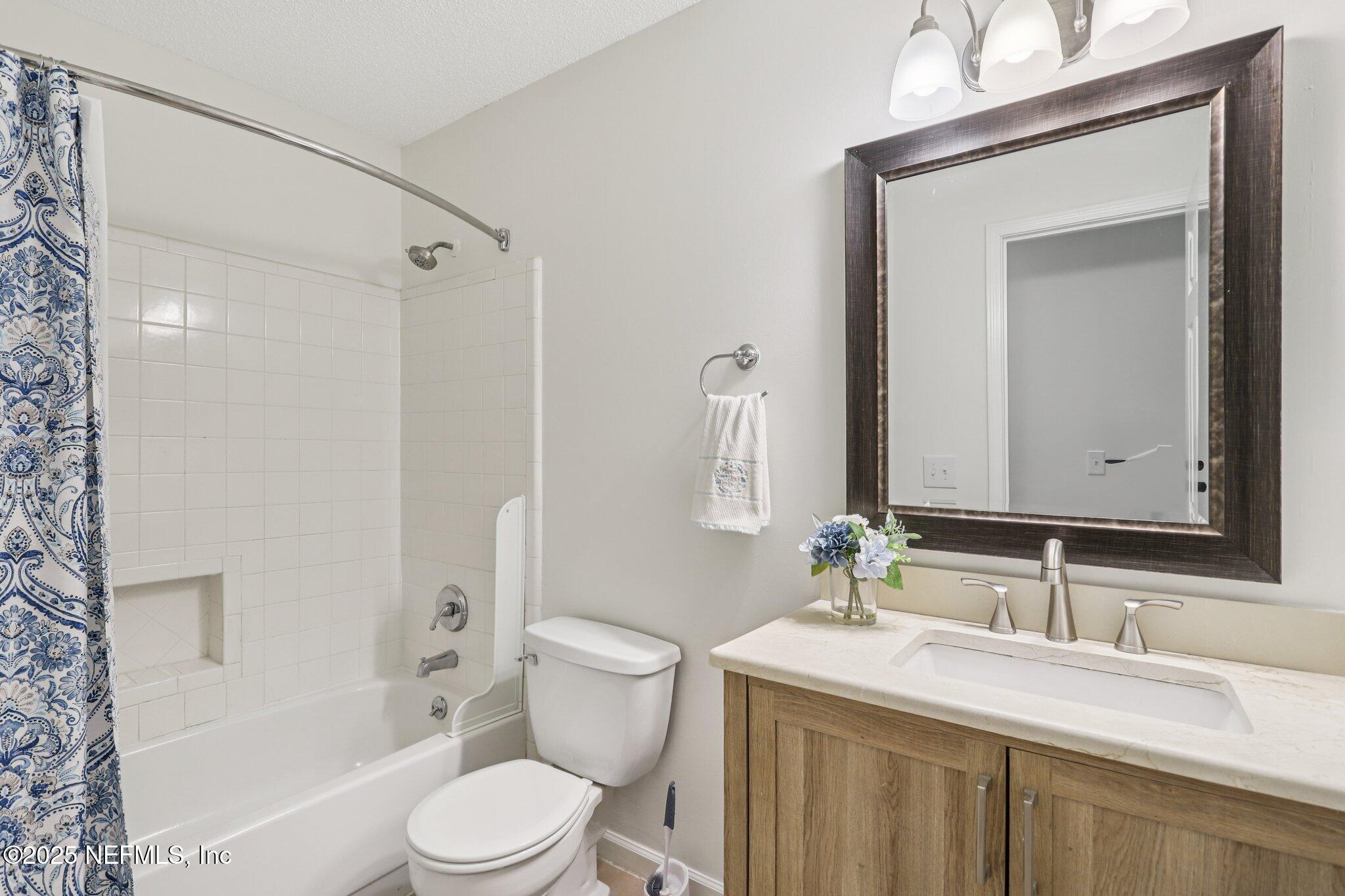 3801 Crown Point Road, Unit 2024 Jacksonville, FL 32257 - Photo 16 of 36 a bathroom with a granite countertop sink toilet a mirror and shower