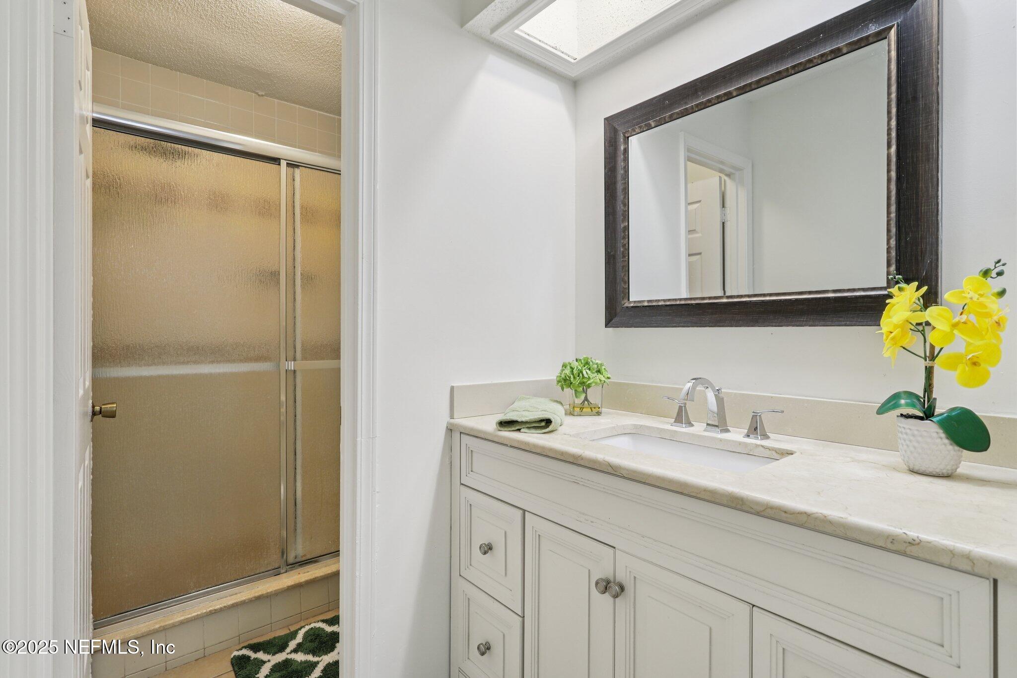 3801 Crown Point Road, Unit 2024 Jacksonville, FL 32257 - Photo 18 of 36 a bathroom with a granite countertop sink and a mirror