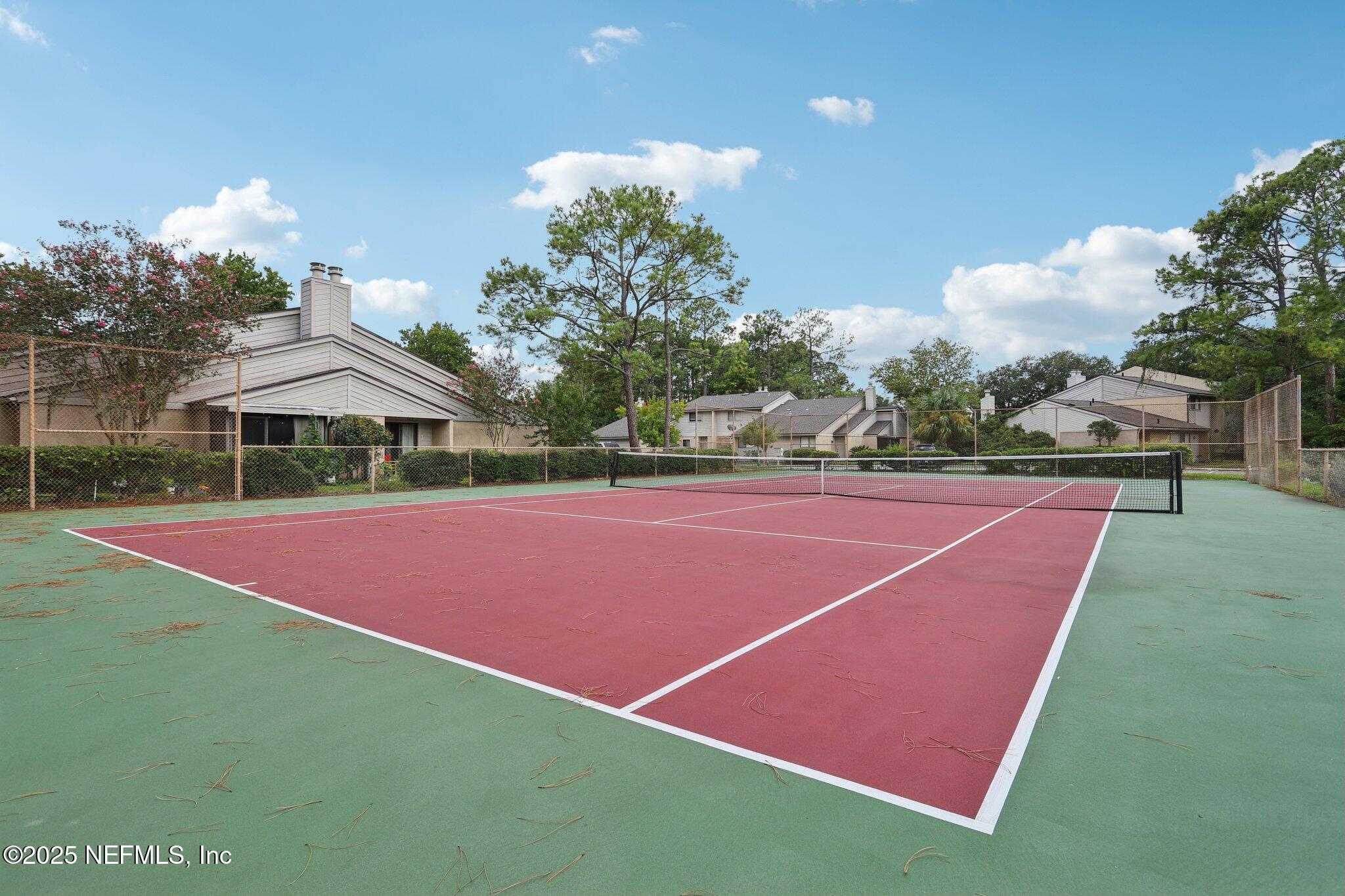 3801 Crown Point Road, Unit 2024 Jacksonville, FL 32257 - Photo 34 of 36 a tennis court with lots of trees in the background