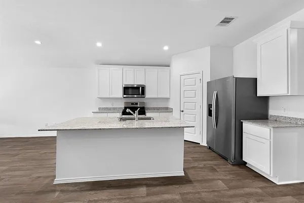 a kitchen with stainless steel appliances a refrigerator and a stove top oven
