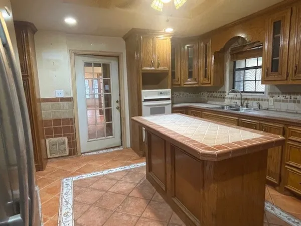 a kitchen with granite countertop a sink and a stove
