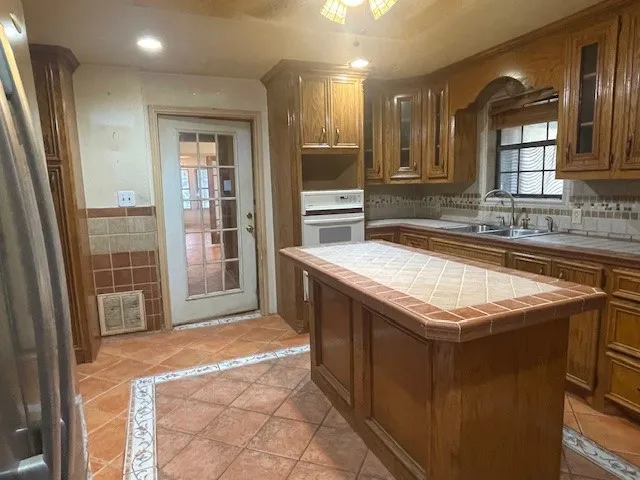 a kitchen with granite countertop a sink and a stove