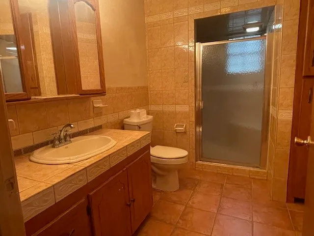 a bathroom with a granite countertop sink toilet and shower