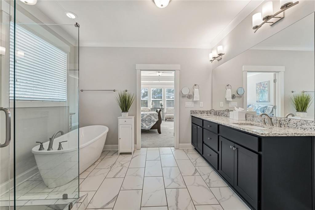 920 Traditions Way Jefferson, GA 30549 - Photo 20 of 40 a spacious bathroom with a double vanity sink a mirror and a bathtub