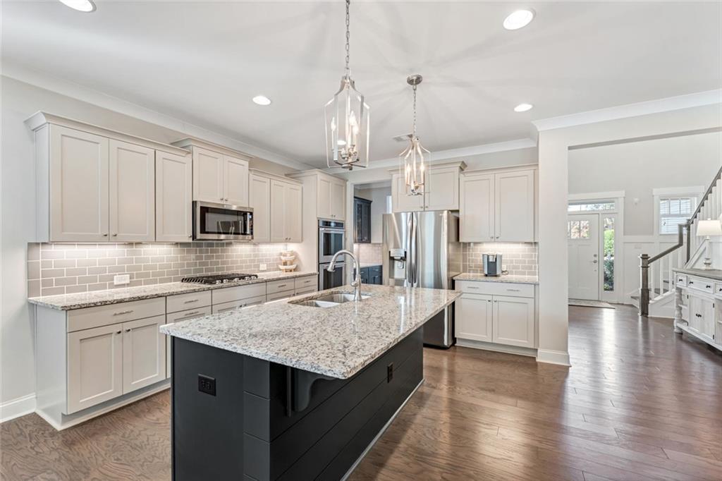 920 Traditions Way Jefferson, GA 30549 - Photo 9 of 40 a kitchen with stainless steel appliances granite countertop a sink stove and refrigerator