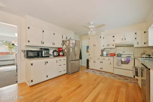 a kitchen with white cabinets and white appliances