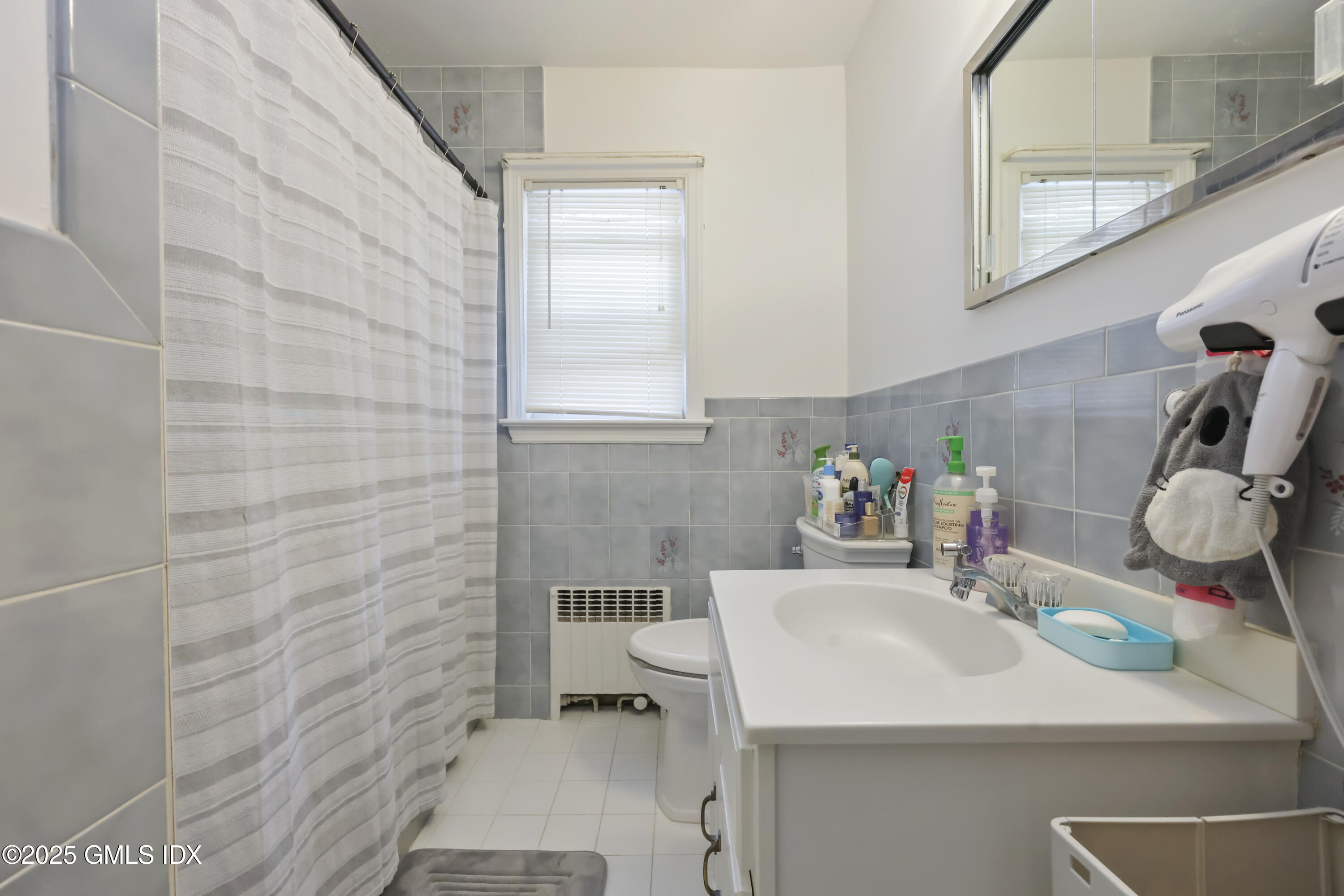 54 Rodwell Avenue, Unit 1 Greenwich, CT 06830 - Photo 7 of 14 a bathroom with a sink a toilet and mirror