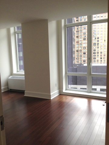 60 Riverside Boulevard, Unit 716 Manhattan, NY 10069 - Photo 6 of 8 a view of an empty room with wooden floor and a window