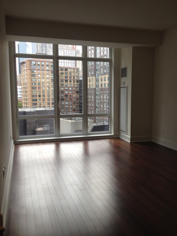 60 Riverside Boulevard, Unit 716 Manhattan, NY 10069 - Photo 7 of 8 a view of an empty room with wooden floor and a window