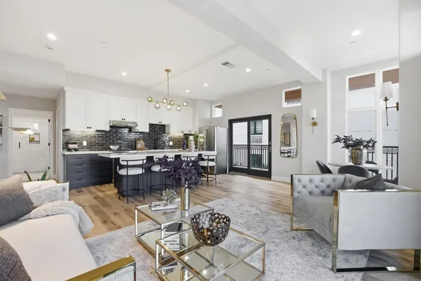 a living room with furniture and kitchen view
