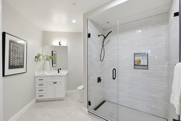 a bathroom with a shower sink and mirror
