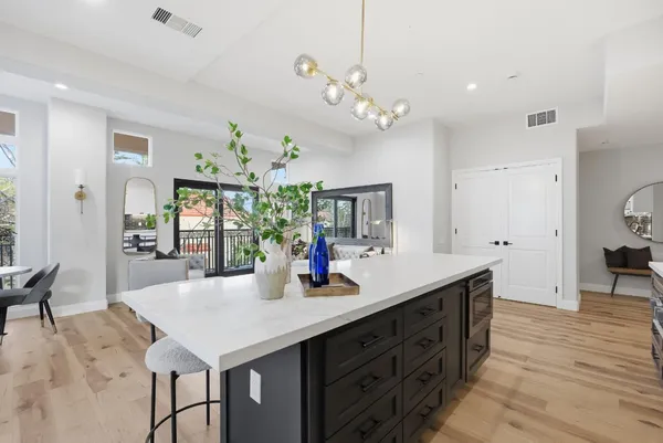 a kitchen with a counter space a sink and living room view