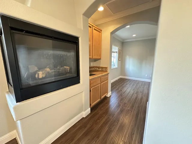 a view of a living room with wooden floor and a fireplace