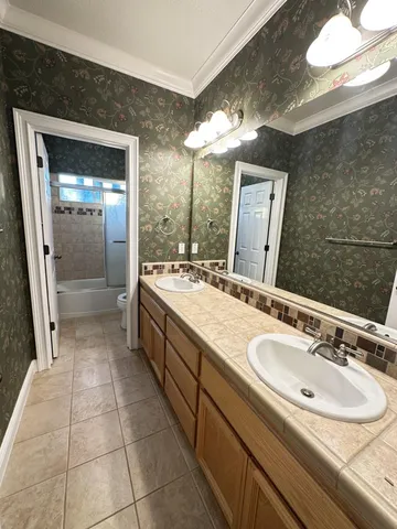 a spacious bathroom with a double vanity sink a mirror and a shower