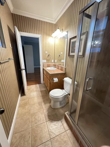 a bathroom with a toilet a sink a mirror and a shower