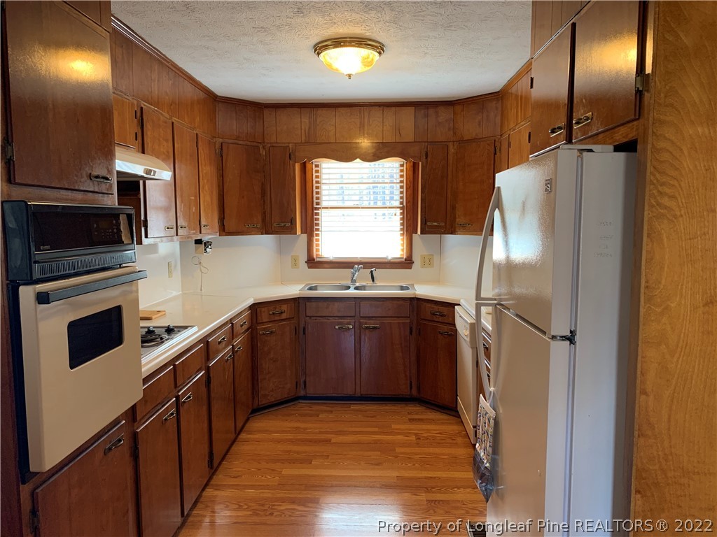 7114 Clinton Road Stedman, NC 28391 - Photo 8 of 34 a kitchen with stainless steel appliances granite countertop a refrigerator a sink dishwasher a oven with wooden cabinets and floor