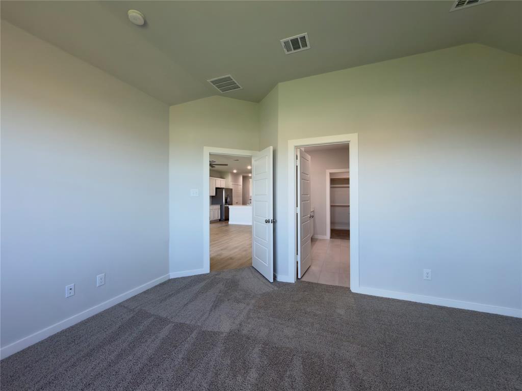 120 Millwood Road Lavon, TX 75166 - Photo 28 of 34 Carpeted room with vaulted ceiling and light-toned walls