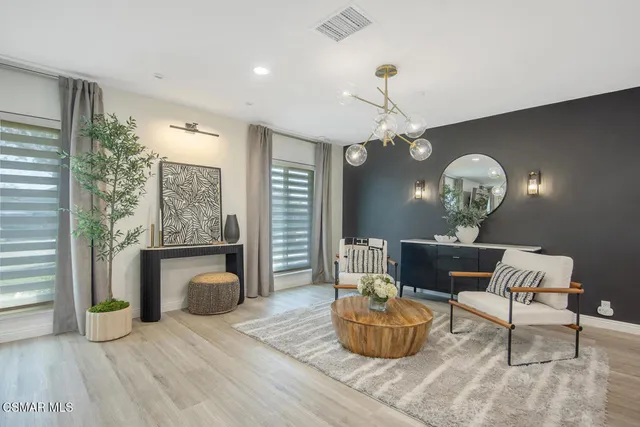 a living room with furniture a chandelier and a fireplace