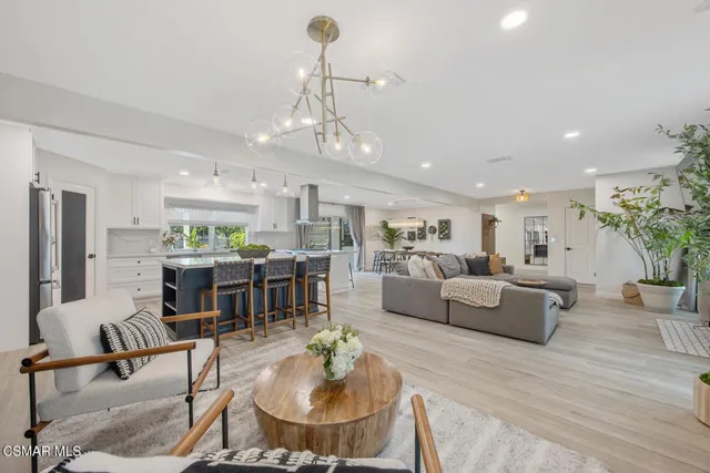 a living room with furniture kitchen and a chandelier