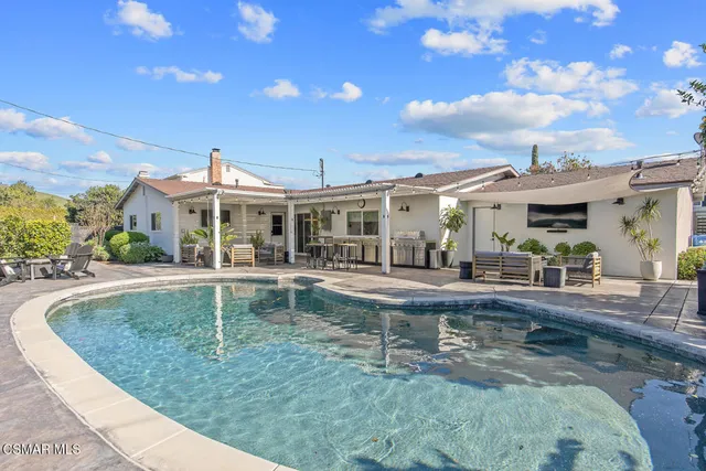 a view of a house with backyard porch and sitting area