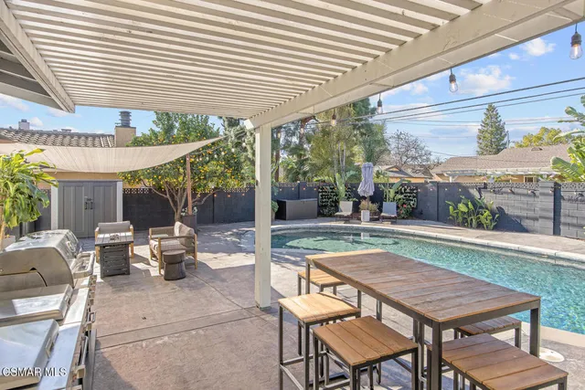 a view of a patio with a dining table and chairs under an umbrella