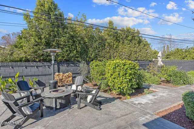 a view of a backyard with sitting area and garden
