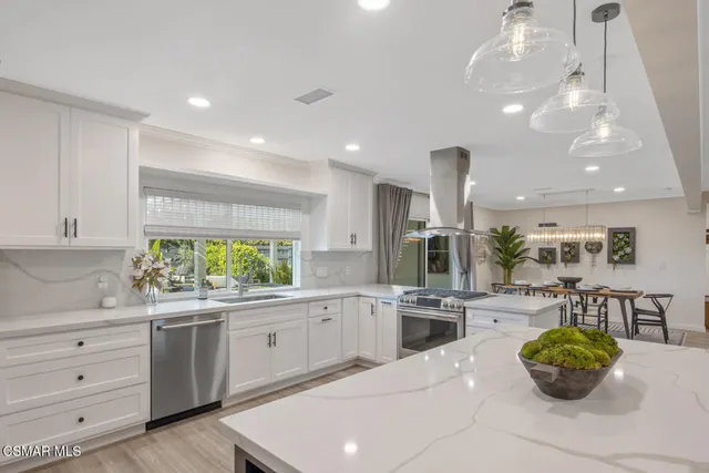 a kitchen with white cabinets and window