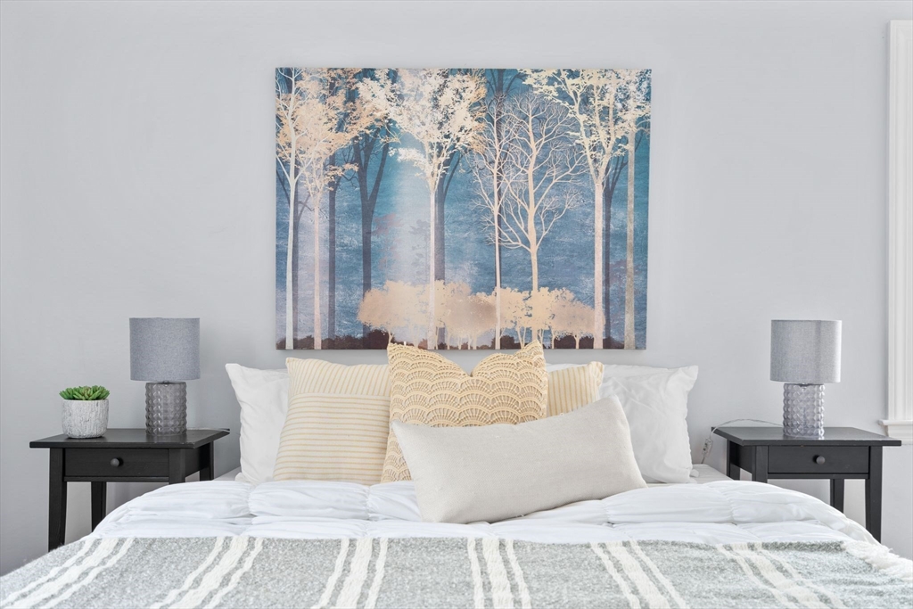 29 Walnut Terrace Arlington, MA 02476 - Photo 19 of 41 a large bed sitting in a bedroom next to a window with lamp