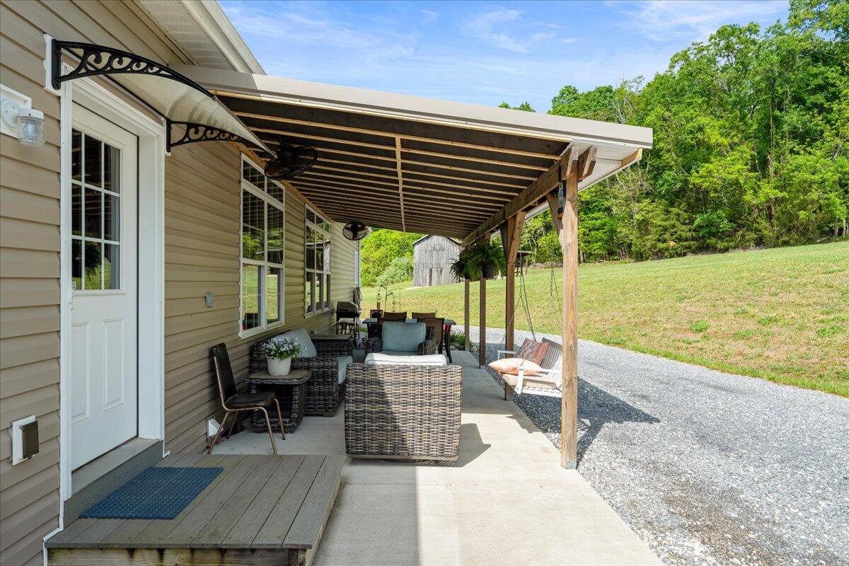 218 Mt Moriah Road Eagle Rock, VA 24085 - Photo 28 of 38 a view of a deck with couches table and chairs under an umbrella