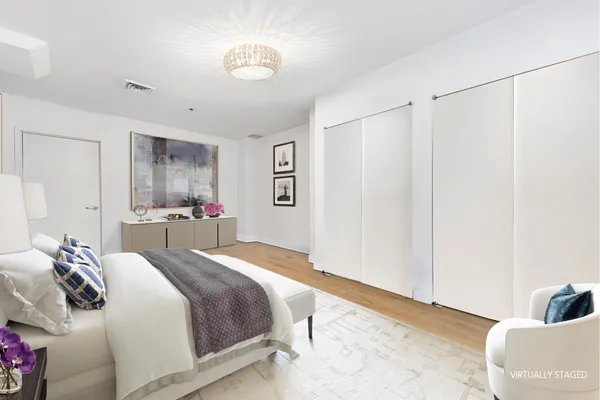 a bedroom with a large bed and a chandelier