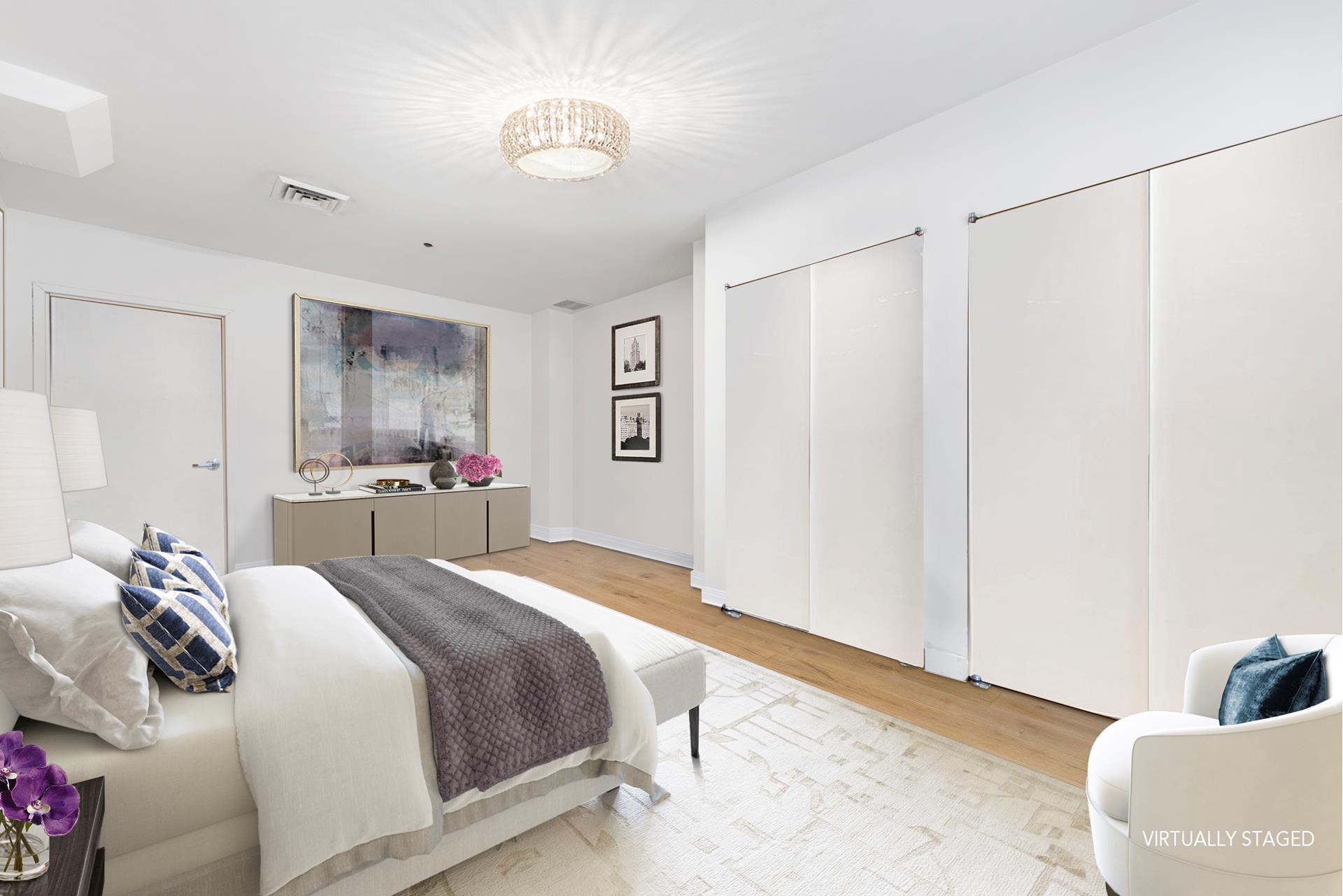 315 West 36th Street, Unit 12B Manhattan, NY 10018 - Photo 7 of 33 a bedroom with a large bed and a chandelier