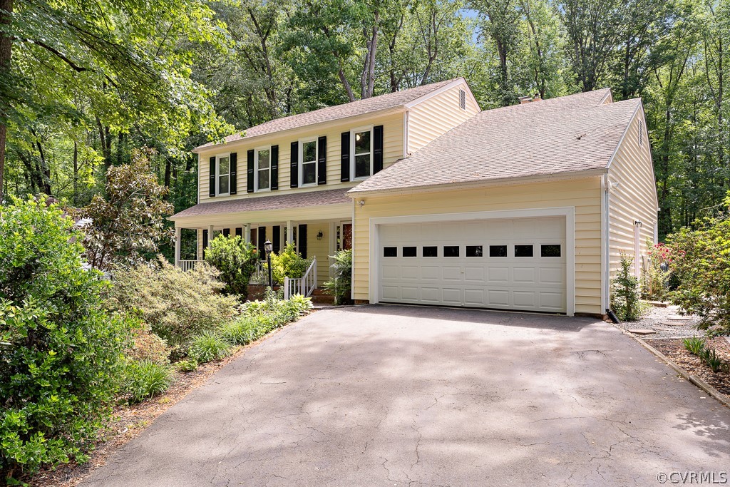 a front view of a house with a garden and trees