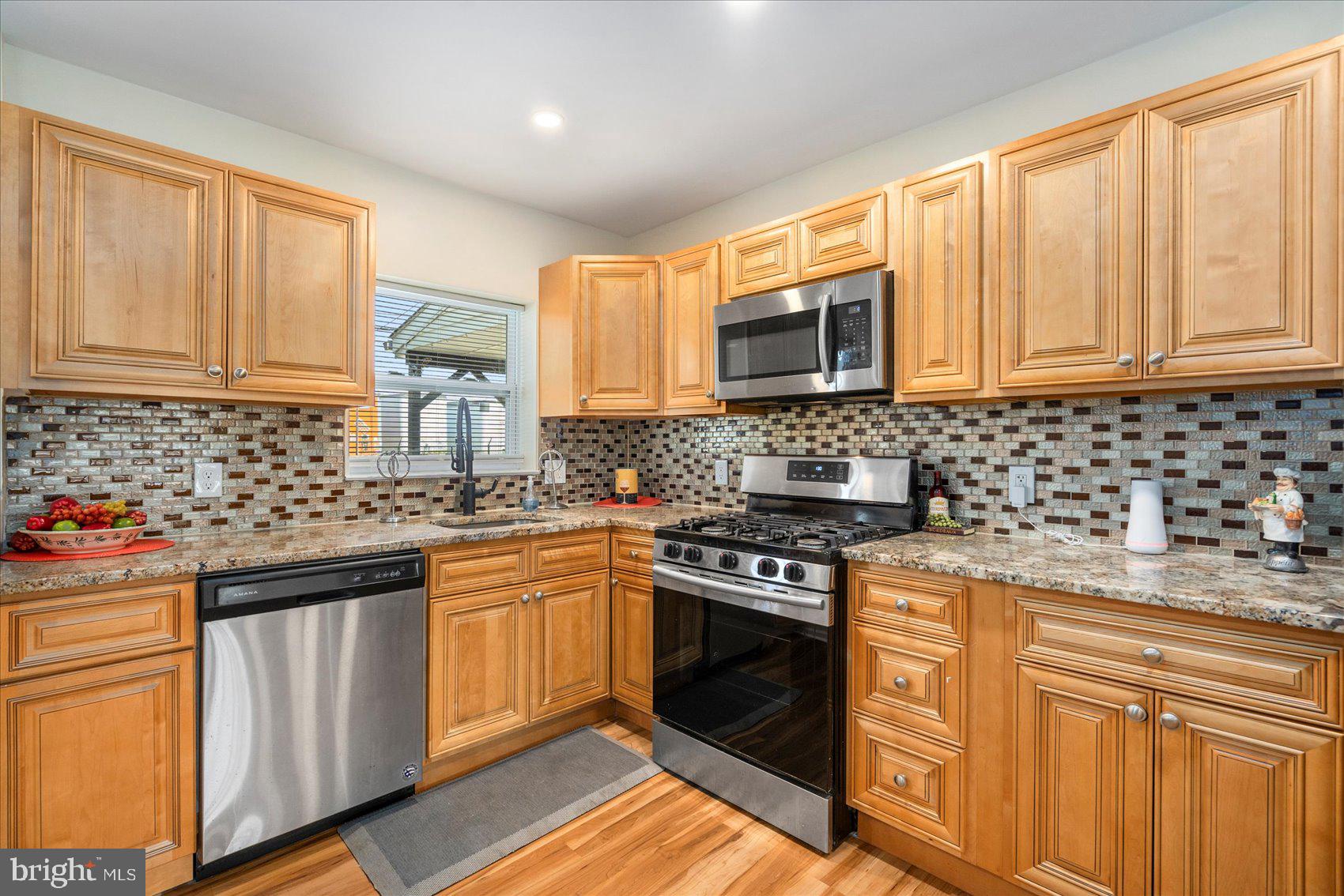 7932 Kavanagh Road Dundalk, MD 21222 - Photo 12 of 39 a kitchen with stainless steel appliances granite countertop a stove a sink dishwasher and a refrigerator