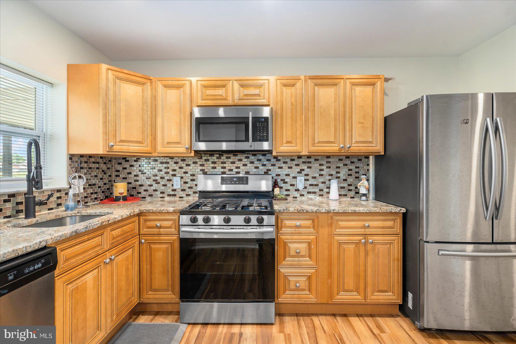7932 Kavanagh Road Dundalk, MD 21222 - Photo 15 of 39 a kitchen with a stove a refrigerator and a sink